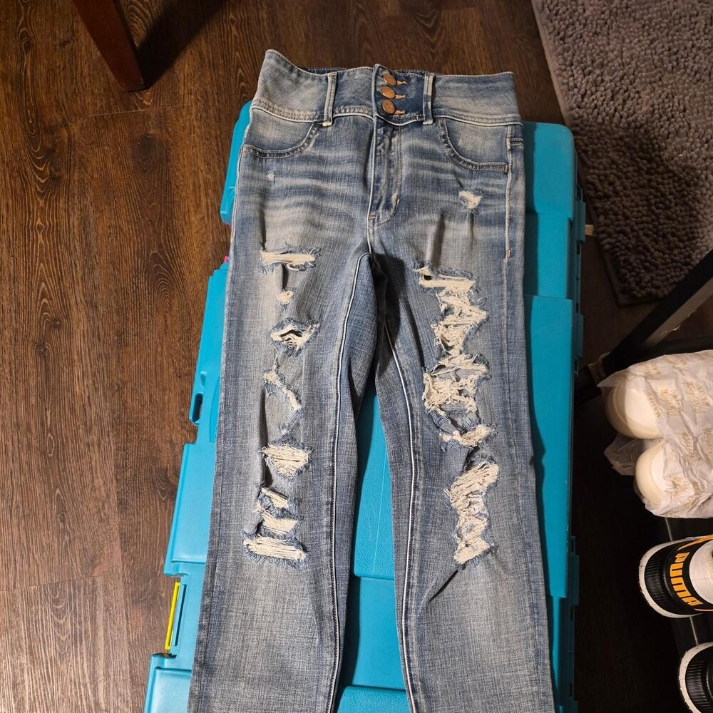 American Eagle High-waisted, distressed, ripped blue denim jeans with a grunge v